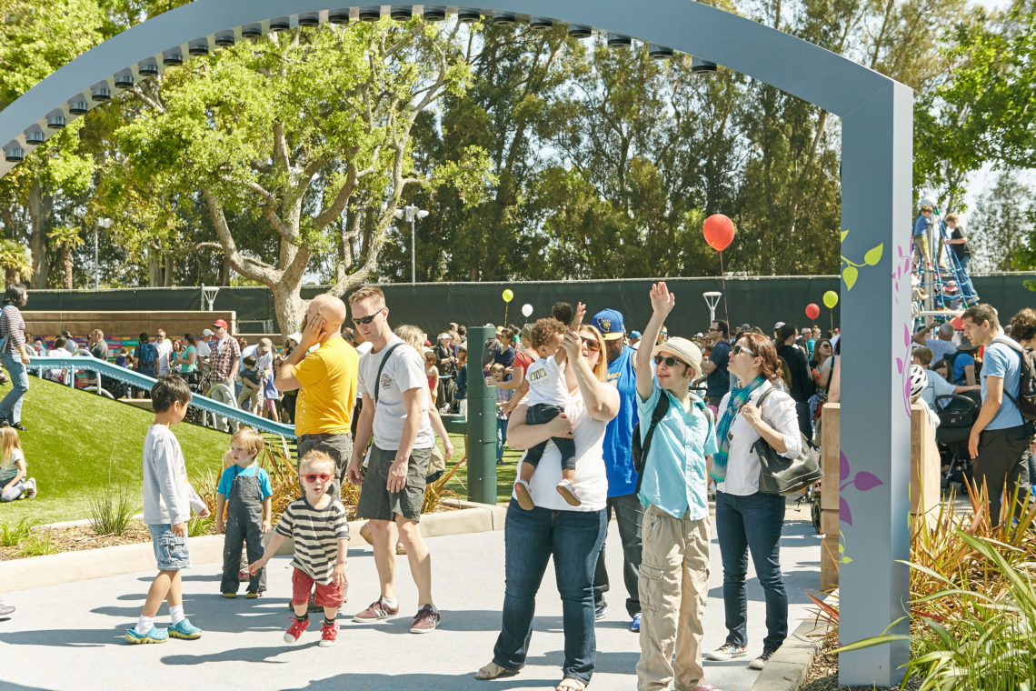 Children and adults interact with the Magical Harp by light artist Jen Lewin